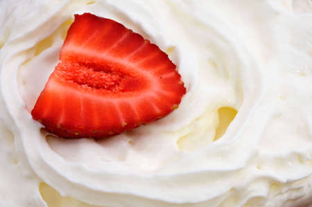 a red strawberry on white creamの写真素材