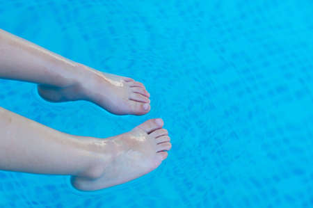 feet refreshing in swimming pool in summerの写真素材