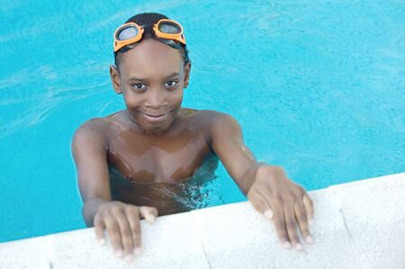 Black boy with glasses in the swimming poolの写真素材