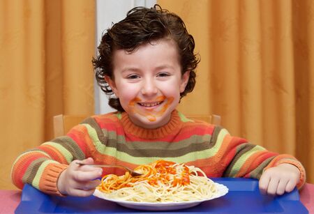 Adorable child eating in his house - focus in the face -の写真素材