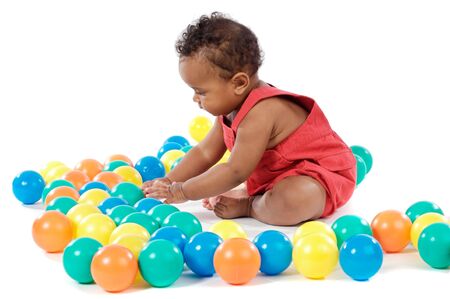 Adorable  girl playing with balls of colorsの写真素材
