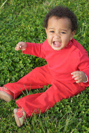 adorable happy baby on the green grassの写真素材