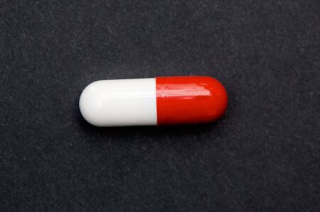 Red and white pill a over black background