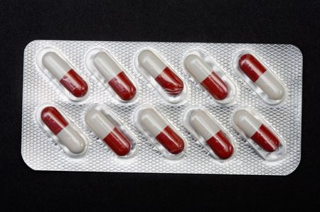 pills in plastic container on a black background