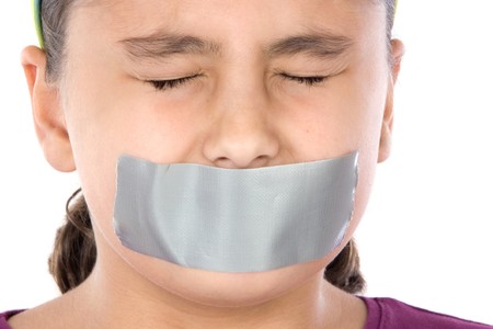 Beautiful girl with adhesive on her mouth and closed eyes isolated over whiteの写真素材