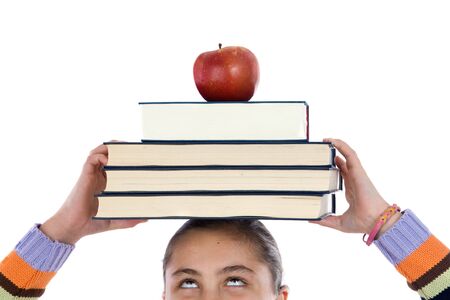 Adorable girl studying with books and apple in the headの写真素材