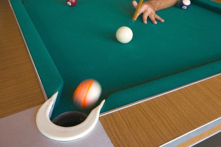 Playing billiards with balls on a green felt table