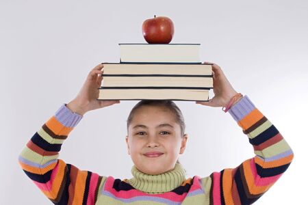 Adorable girl studying with books and apple in the headの写真素材