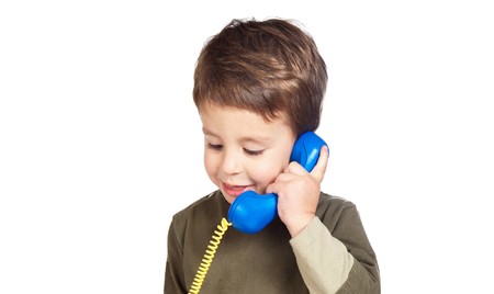 Adorable child on the phone isolated over whiteの写真素材