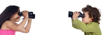 Two children looking throuth the binoculars a over white backgroundの写真素材