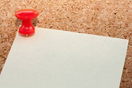 Red pin with note pinned to cork noticeboardの写真素材