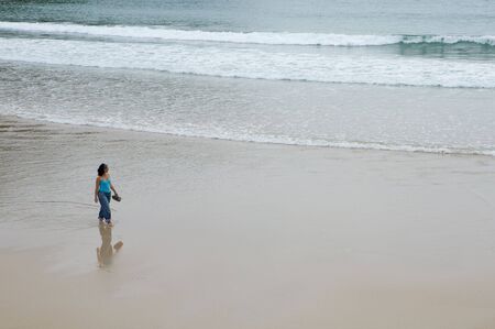 Beautiful girl on the beach looking the seaの写真素材