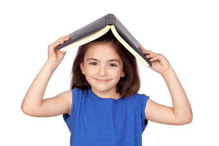 Brunette little girl with a book on her head isolated on a over white backgroundの写真素材