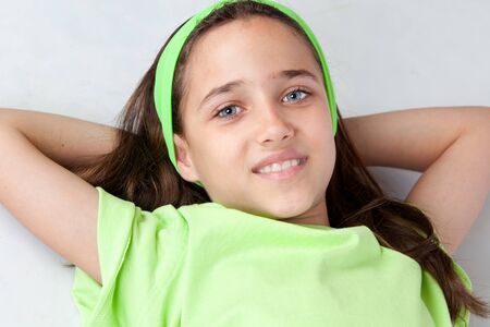 Adorable little girl with blue eyes lying isolated on white backgroundの写真素材
