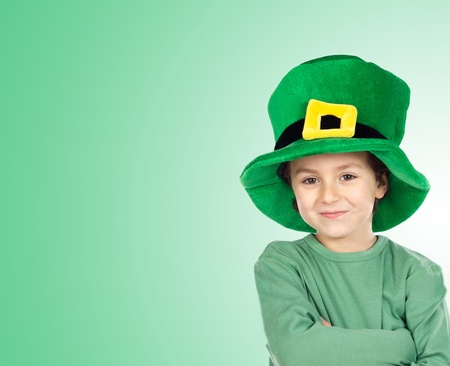 Child with a big hat of Saint Patrick«s Day isolated on a over green backgroundの写真素材