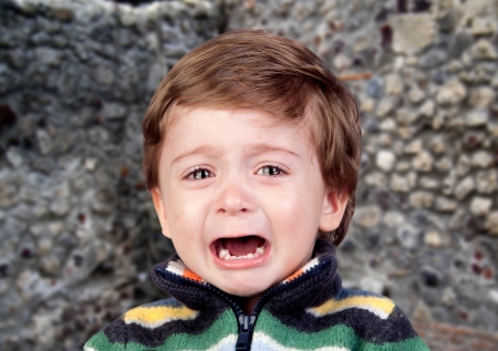 Beautiful baby crying with a wall of backgroundの写真素材