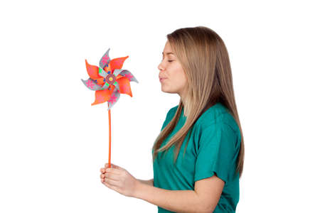 Funny girl blowing a pinwheel isolated on white backgroundの写真素材