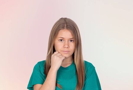 Depressed teen girl thinking isolated on orange background