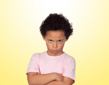 Angry latin child isolated on yellow backgroundの写真素材