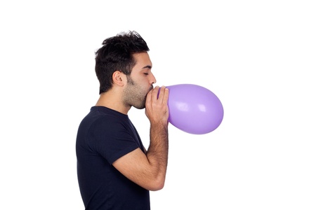 Attractive young men swelling a purple balloon isolated on white backgroundの写真素材