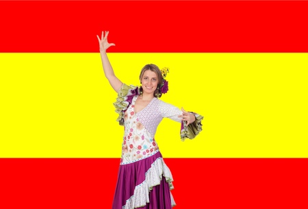 Spanish girl dressed in traditional costume Andalusian dancing on a over red and yellow backgroundの写真素材
