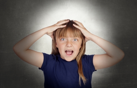 Surprised funny girl with a gray backgroundの写真素材