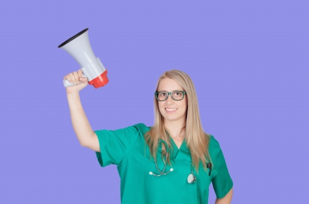 Atractive medical girl with a megaphone on a blue backgroundの写真素材