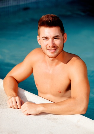 Handsome man in the pool relaxing on the summerの写真素材