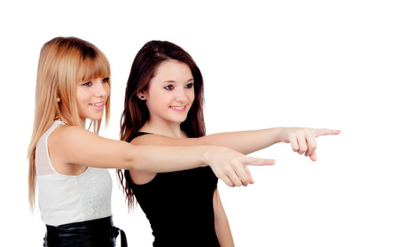 Two teen sisters pointing isolated on white backgroundの写真素材