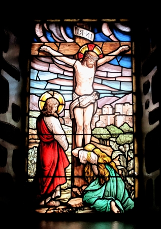 Colorful window with the image of the crucified Jesus and Mary cryingの写真素材