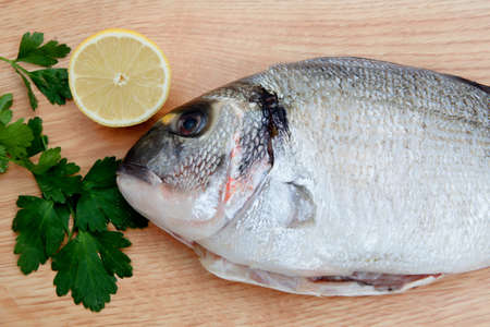 Photo of a healthy fresh fish on wooden board