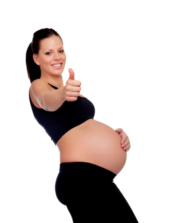 Brunette pregnant woman saying Ok isolated on a white backgroundの写真素材