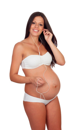 Beautiful pregnant listening to music isolated on a white backgroundの写真素材