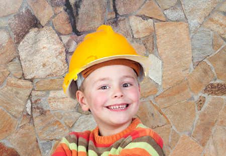 Young funny constructor with a stone wall of backgroundの写真素材