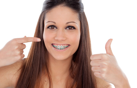 Attractive young woman with brackets saying Ok isolated on a white backgroung