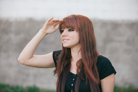 Rebellious teenager girl with red hair looking at sideの写真素材