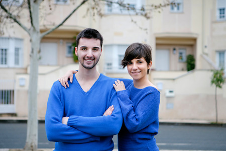 Young lovers dressed in blue excited about your new homeの写真素材