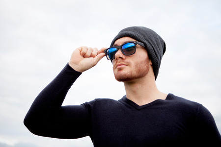 Handsome cool young man with sunglasses and cap woolの写真素材