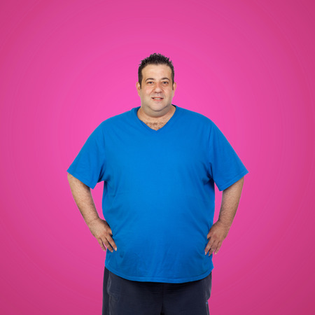 Happy fat man with blue shirt and a pink backgroundの写真素材