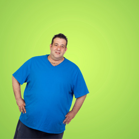 Happy fat man with blue shirt and a green backgroundの写真素材