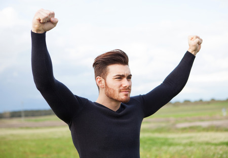 Happy winner strong man in the meadowの写真素材