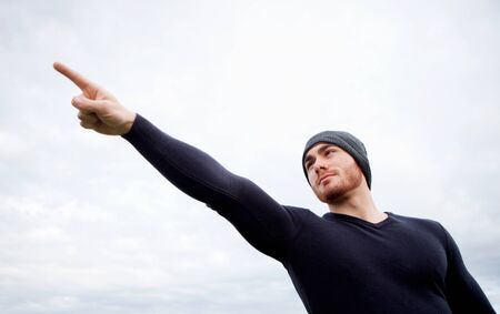 Cool handsome guy with beard at outside pointing somethingの写真素材