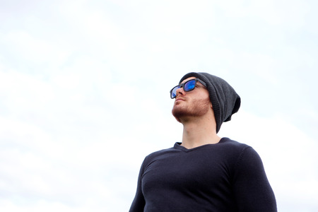 Handsome cool man with cap wool looking awayの写真素材