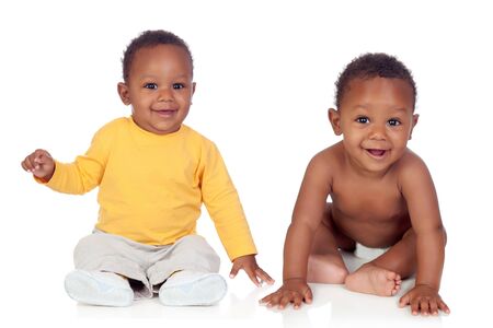 Couple of twins sitting on the floor isolated on a white backgroundの写真素材