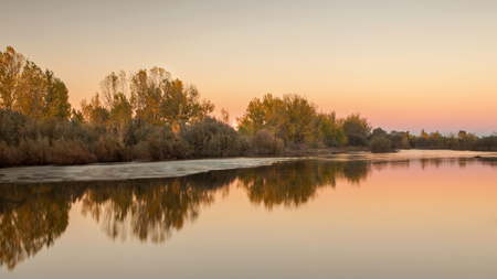 Beautiful autumn landscape. Trees along the banks of a river.の写真素材