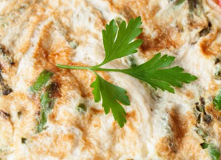 Asparagus omelette with a sprig of parsley on topの写真素材