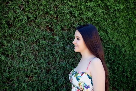 Young teen relaxed outdoors with a natural green background