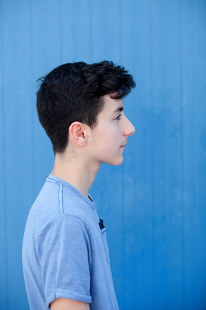 Portrait of a teenager rebellious man with a blue backgroundの写真素材