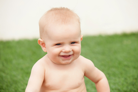 Little baby six month with blue eyes and blond hair gesturingの写真素材