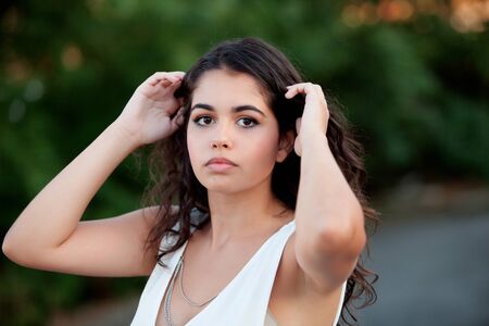 Beautiful brunette girl relaxing in the park wiht many plants of backgroundの写真素材